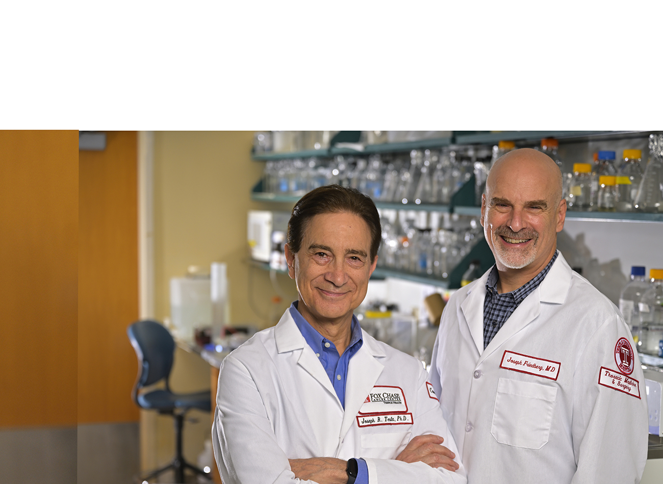 Dr. Testa and Dr. Friedberg standing in a laboratory and smiling.