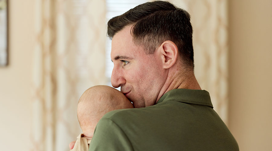 Josh Breen kissing his baby