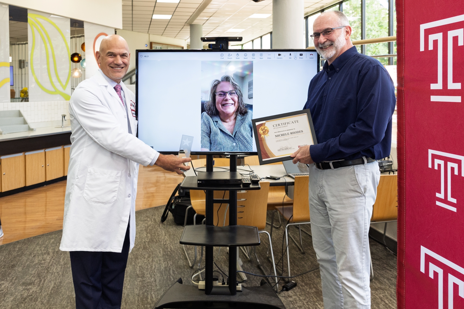 Michele Rhodes (center, on the monitor) with Robert Uzzo, MD, MBA, FACS (left), and David Wiest, PhD