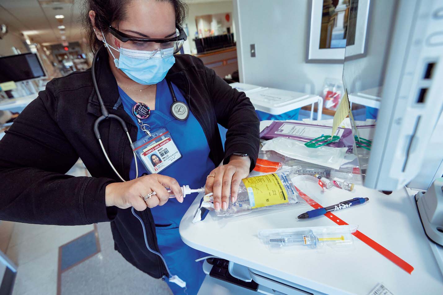 A bone marrow transplant nurse gathers supplies to begin a patient's treatment.