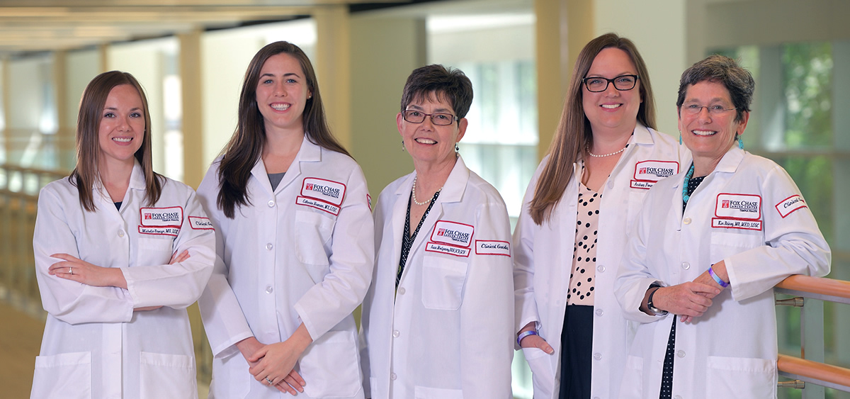 A photograph of five Fox Chase doctors smiling at the camera inside of a medical facility.