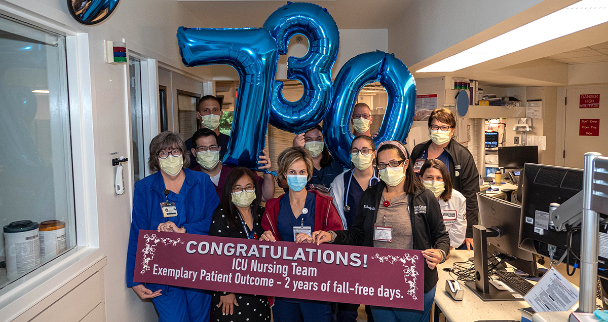 "A group of nurses with the sign Congratulations! ICU Nursing Team Exemplary Patient Outcome - 2 years of fall-free days."