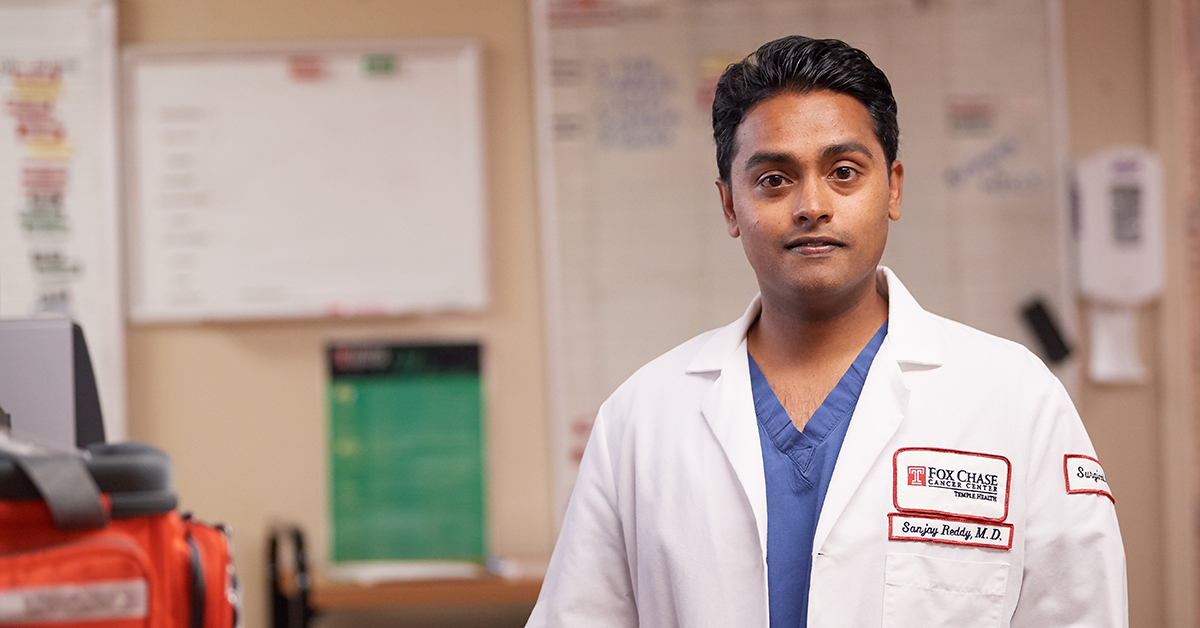 A photo of Dr. Sanjay Reddy, a pancreatic cancer surgeon at Fox Chase, standing in a medical room.