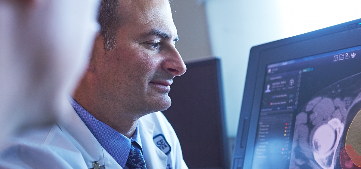 A closeup shot of two people looking at a screen with medical imaging results on it.