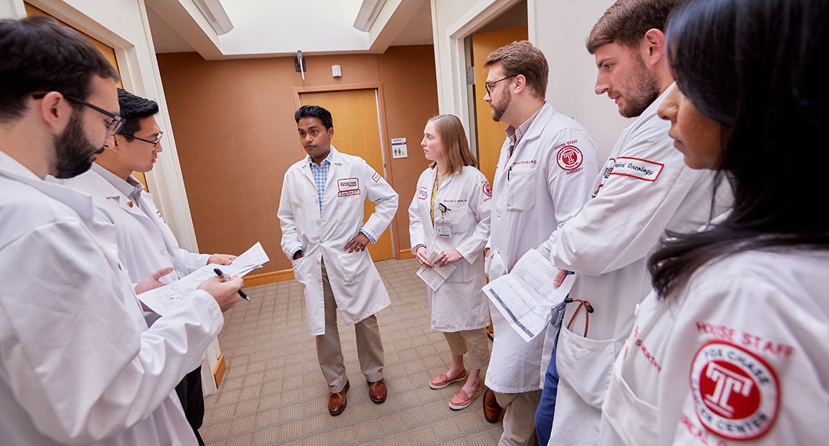 A photograph of Dr. Reddy discussing his patient’s care with several residents, fellows, nurses, and others on the care team.