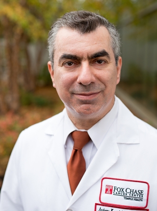A portrait shot of Dr. Andreas Karachristos, smiling and looking at the camera. 