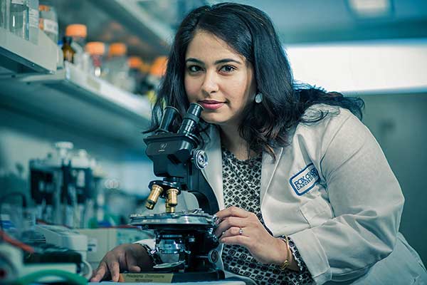 Sanjeevani Arora of the Cancer Prevention and Control Program is researching the effectiveness of treatments for colorectal cancer. She is shown here at the microscope used to identify the Philadelphia chromosome at Fox Chase in 1959, the first conclusive evidence linking cancer and genetics.