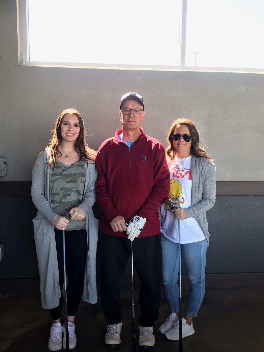 William and his two daughters getting ready to play golf.