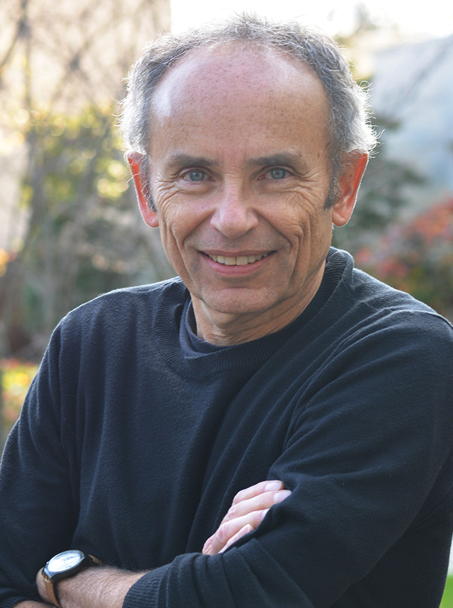 A portrait shot of Christoph Seeger crossing his arms as he smiles at the camera.