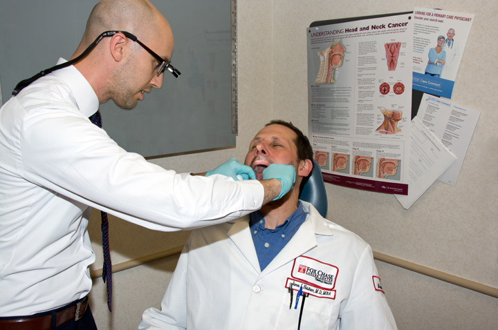 Dr. Fundakowski performs a screening on his colleague, Dr. Helstrom.