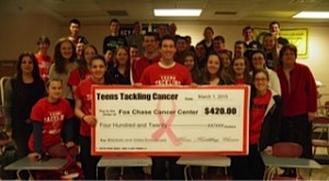 A photograph of a group of teens from Hatboro-Horsham High School holding a large check that says "Teens Tackling Cancer."