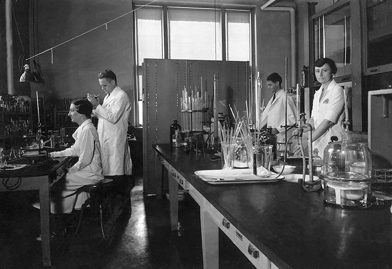 The lab of organic chemist Gerrit Toennies in the Wanamaker building on the Lankenau Hospital campus in 1935. Shown left to right are Peg Elliott, Toennies, Theodore Lavine, and Mary Adelia Bennett.
