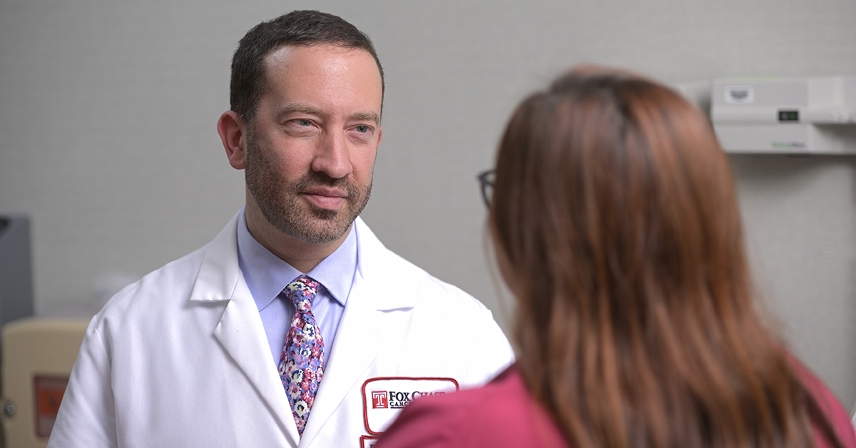 A photograph from over a patient's shoulders as they speak to a Fox Chase doctor.