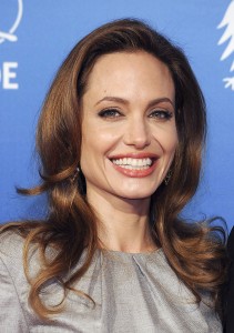 A portrait shot of Angelina Jolie on a blue backdrop.