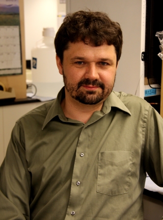A photograph of Alexei Tulin, associate professor at Fox Chase Cancer Center, sitting as he looks at the camera.