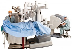 A cutout photograph of a robotic surgery, with two medical professionals assisting it. 