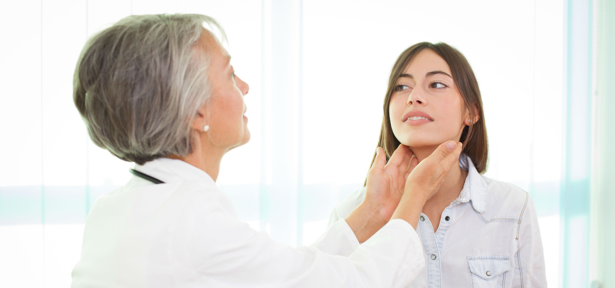 A photograph of a medical professional feeling the sides of a patient's neck.