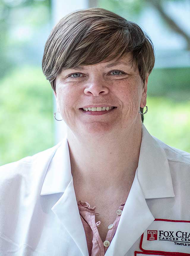 Caryn M. Vadseth, a female certified registered nurse practitioner wearing a white coat and smiling