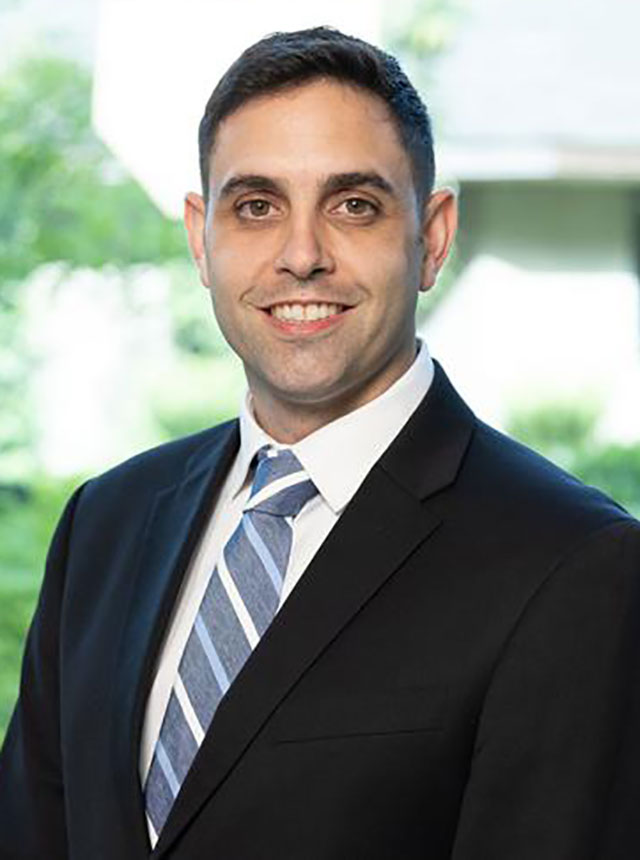 Eric M. Ghiraldi, a male urologist, wearing a suit and smiling