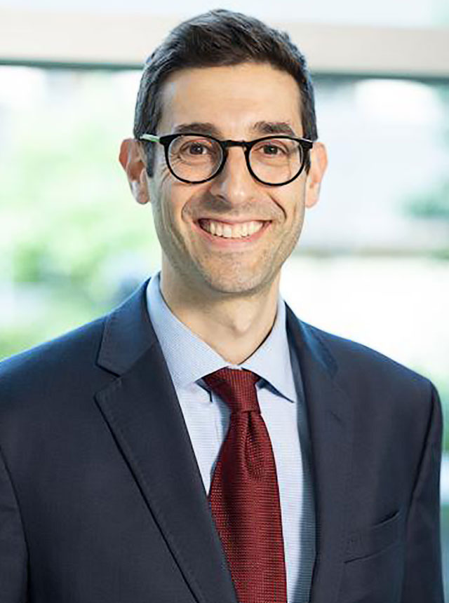 A close-up of Joshua Cohn, a male urologist at Temple Health, wearing glasses and smiling 