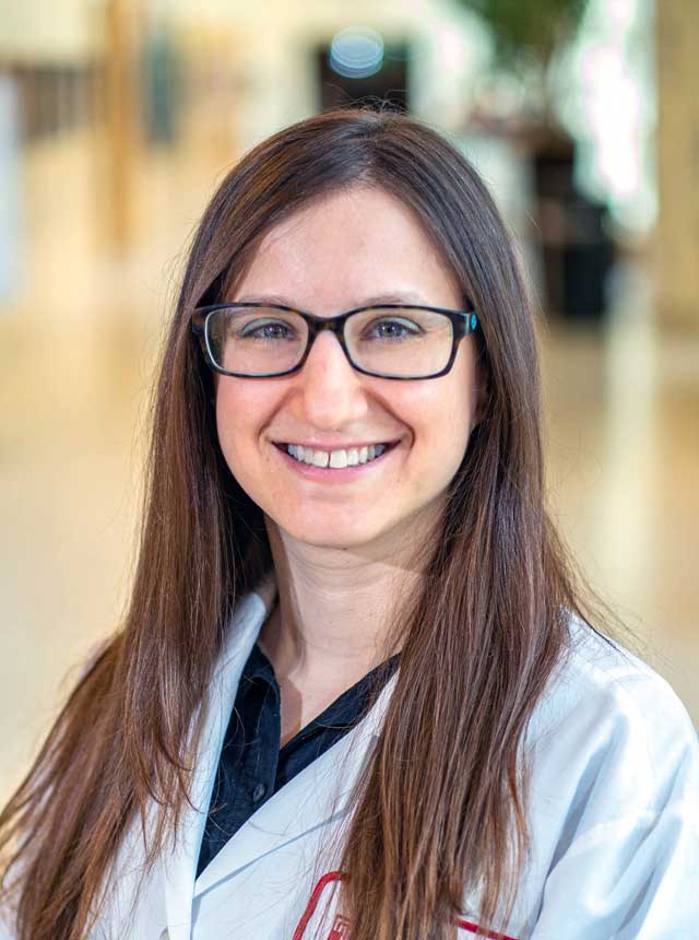 Malorie K. Simons, MD headshot, wearing a white coat and glasses