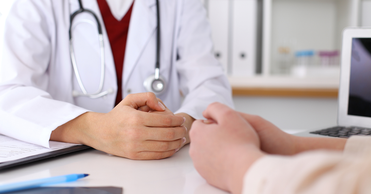 Clinician discussing procedures with a potential patient, wearing a lab coat