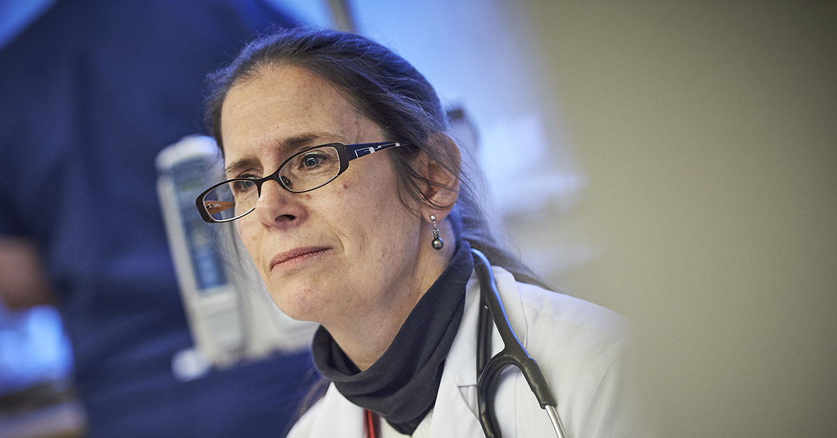 A close up photo of a medical professional looking off camera, with the right half of the image obscured.