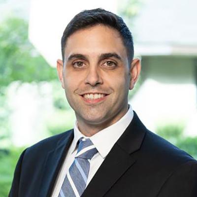 Eric M. Ghiraldi, a male urologist, wearing a suit and smiling