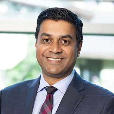 Jay Simhan, a male urologist, wearing a suit and smiling