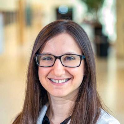 Malorie K. Simons, MD headshot, wearing a white coat and glasses