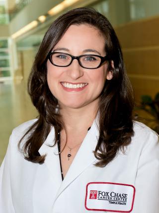Allison Aggon, DO, wearing a white coat and smiling