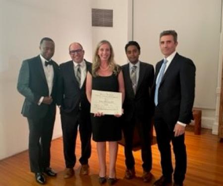 Dr. Porpiglia holding her induction certificate surrounded by 4 of her peers