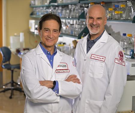 Dr. Testa and Dr. Friedberg standing in a laboratory and smiling.
