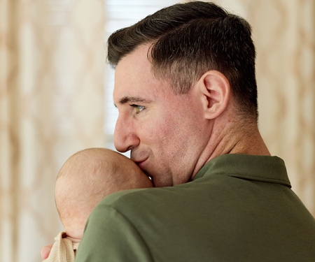 Josh Breen kissing his baby