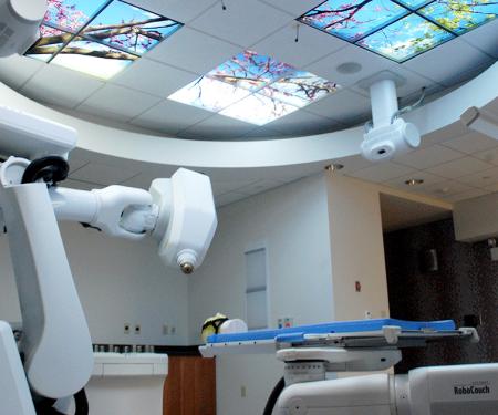 A photograph of a medical room with high tech radiation treatment machines.