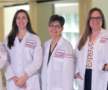 A photograph of five Fox Chase doctors smiling at the camera inside of a medical facility.