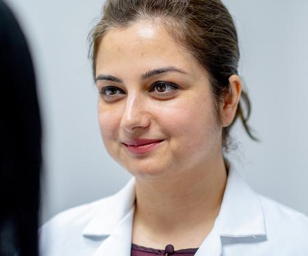 A close up photograph of a medical professional smiling at another person.