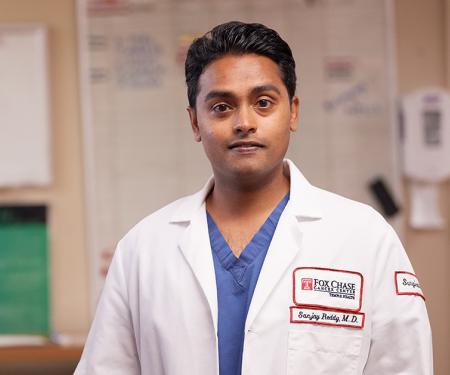 A photo of Dr. Sanjay Reddy, a pancreatic cancer surgeon at Fox Chase, standing in a medical room.