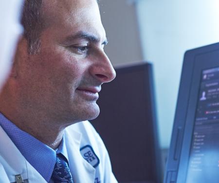 A closeup shot of two people looking at a screen with medical imaging results on it.