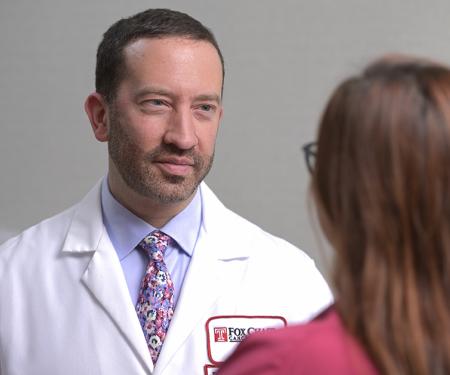 A photograph from over a patient's shoulders as they speak to a Fox Chase doctor.