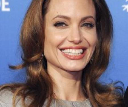 A portrait shot of Angelina Jolie on a blue backdrop.