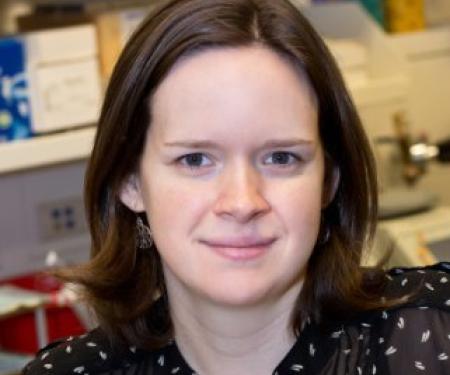 A portrait shot of Jessica Wagner in a laboratory, smiling at the camera.