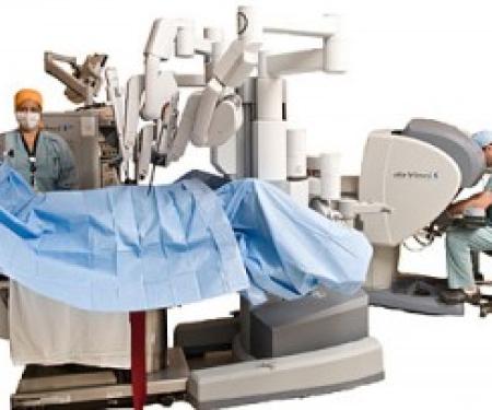 A cutout photograph of a robotic surgery, with two medical professionals assisting it.