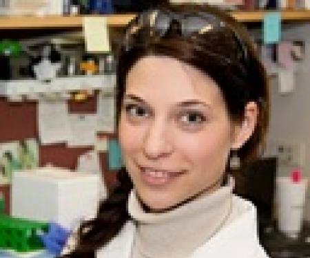 A portrait shot of Galina Semenova in a laboratory, smiling at the camera.