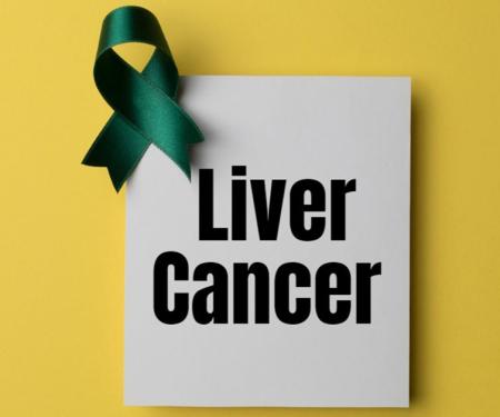 A paper reading "Liver Cancer" in bold black lettering with a green ribbon atop the corner, set on a yellow background.