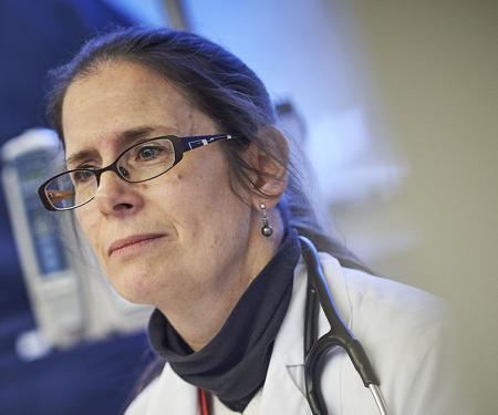 A close up photo of a medical professional looking off camera, with the right half of the image obscured.