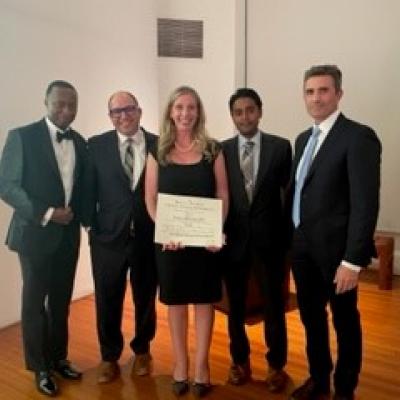 Dr. Porpiglia holding her induction certificate surrounded by 4 of her peers