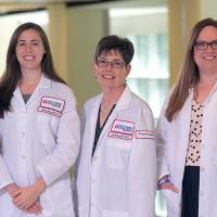 A photograph of five Fox Chase doctors smiling at the camera inside of a medical facility.
