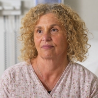 A photograph of a doctor and patient facing each other in a medical room.
